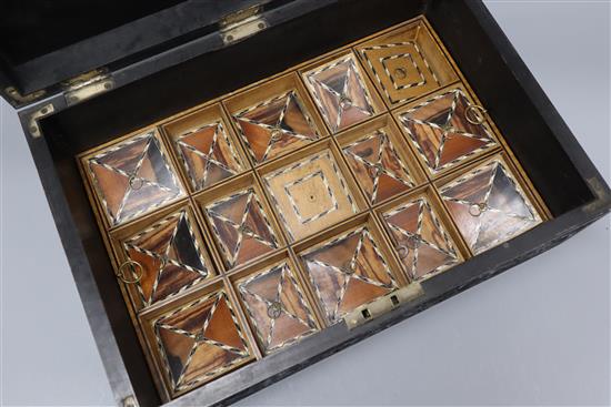 An Anglo-Ceylonese carved ebony box with ivory inlay, with specimen wood section lids to interior, 19th century length 42cm